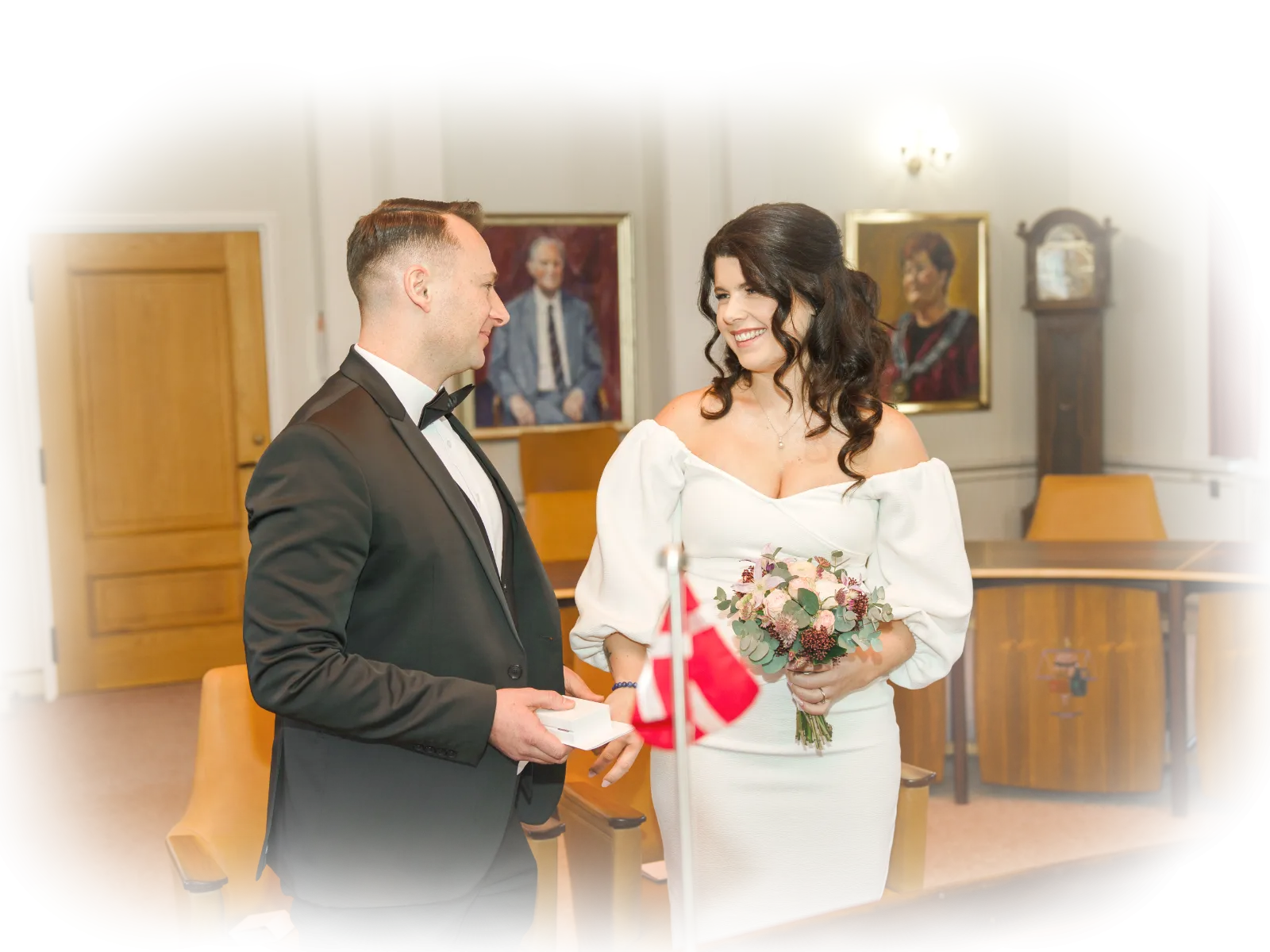 Eine Braut im Hochzeitskleid und der Bräutigam im Anzug, bei in den mittleren Jahren, haben sich gerade das Ja-Wort gegeben in dänischem Standesamt